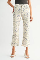 Woman wearing high rise floral kick flare jeans with a cropped length and subtle flare paired with a fitted top