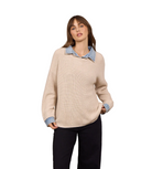 Model wearing a relaxed-fit knit sweater with an attached denim collar and cuff details paired with dark pants.