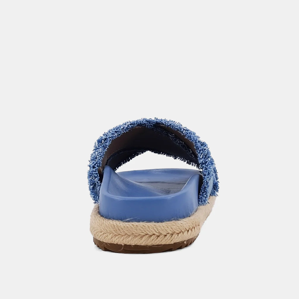 Courtney Sandal Denim. Upgrade your summer wardrobe with these slip-on sandals. Experience unparalleled comfort with its molded footbed and enjoy the stylish blue distressed denim textile fabric complementing any casual outfit. The rope-detailed outsole adds a touch of sophistication to this chic and versatile sandal