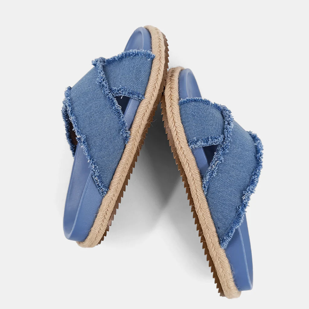 Courtney Sandal Denim. Upgrade your summer wardrobe with these slip-on sandals. Experience unparalleled comfort with its molded footbed and enjoy the stylish blue distressed denim textile fabric complementing any casual outfit. The rope-detailed outsole adds a touch of sophistication to this chic and versatile sandal.