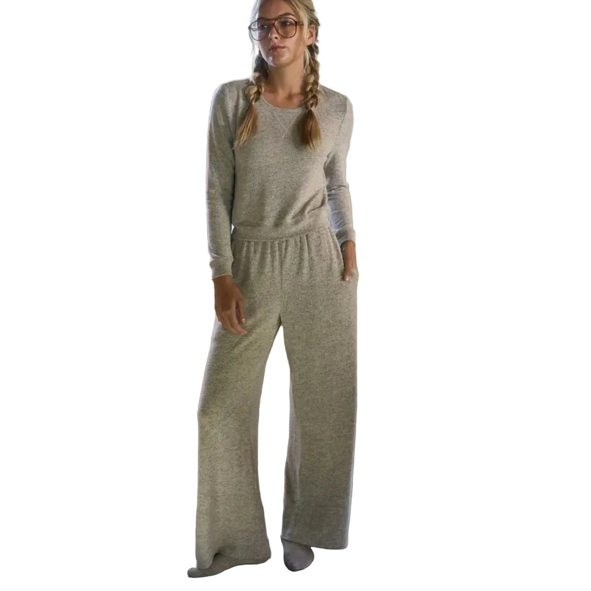 A woman wearing a light heather gray long-sleeve lounge set with matching wide-leg pants, standing in a kitchen environment.