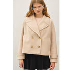 Women's neutral double-breasted cropped peacoat with wide notched lapels, button-tab cuffs, and a relaxed boxy fit