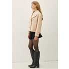Women's neutral double-breasted cropped peacoat with wide notched lapels, button-tab cuffs, and a relaxed boxy fit