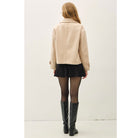 Women's neutral double-breasted cropped peacoat with wide notched lapels, button-tab cuffs, and a relaxed boxy fit