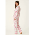 Ivory three-piece holiday pajama set with red Christmas print, button-front top, pants, and matching eye mask