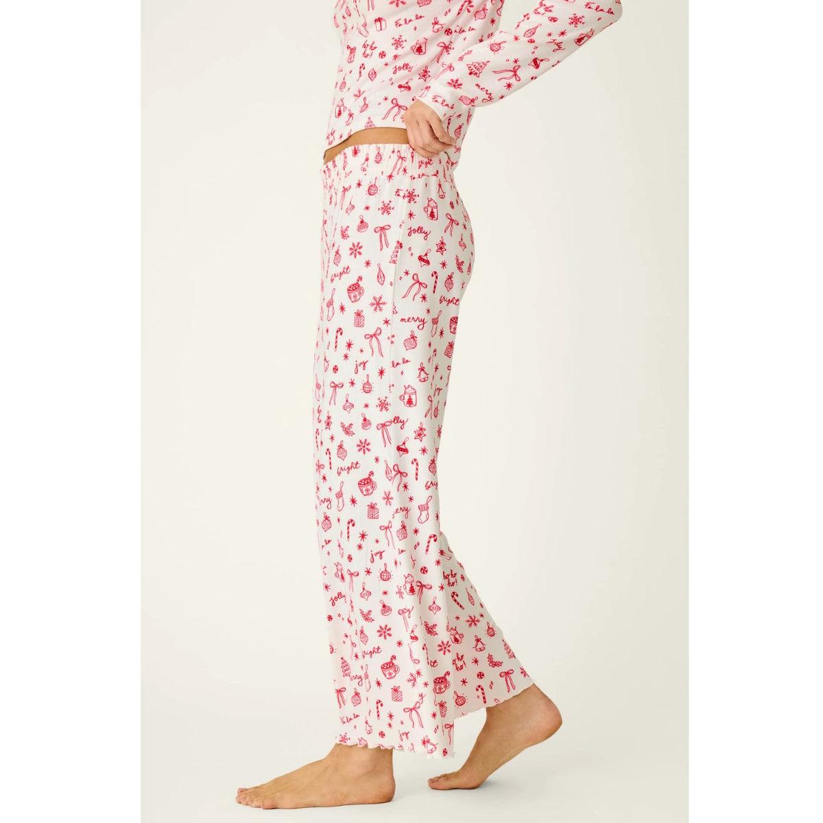 Ivory cropped pajama pants with red holiday print, smocked waistband, and open-leg silhouette