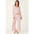 Ivory cropped pajama pants with red holiday print, smocked waistband, and open-leg silhouette