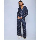 A cozy two-piece sleep set featuring brushed Pillowsoft fabric, a button-front top with contrast piping, and full-length drawstring pants for relaxing in comfort
