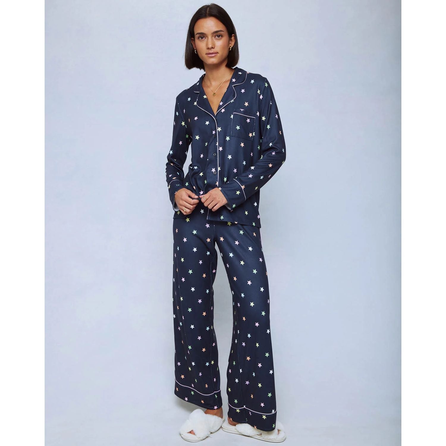 A cozy two-piece sleep set featuring brushed Pillowsoft fabric, a button-front top with contrast piping, and full-length drawstring pants for relaxing in comfort