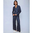 A cozy two-piece sleep set featuring brushed Pillowsoft fabric, a button-front top with contrast piping, and full-length drawstring pants for relaxing in comfort