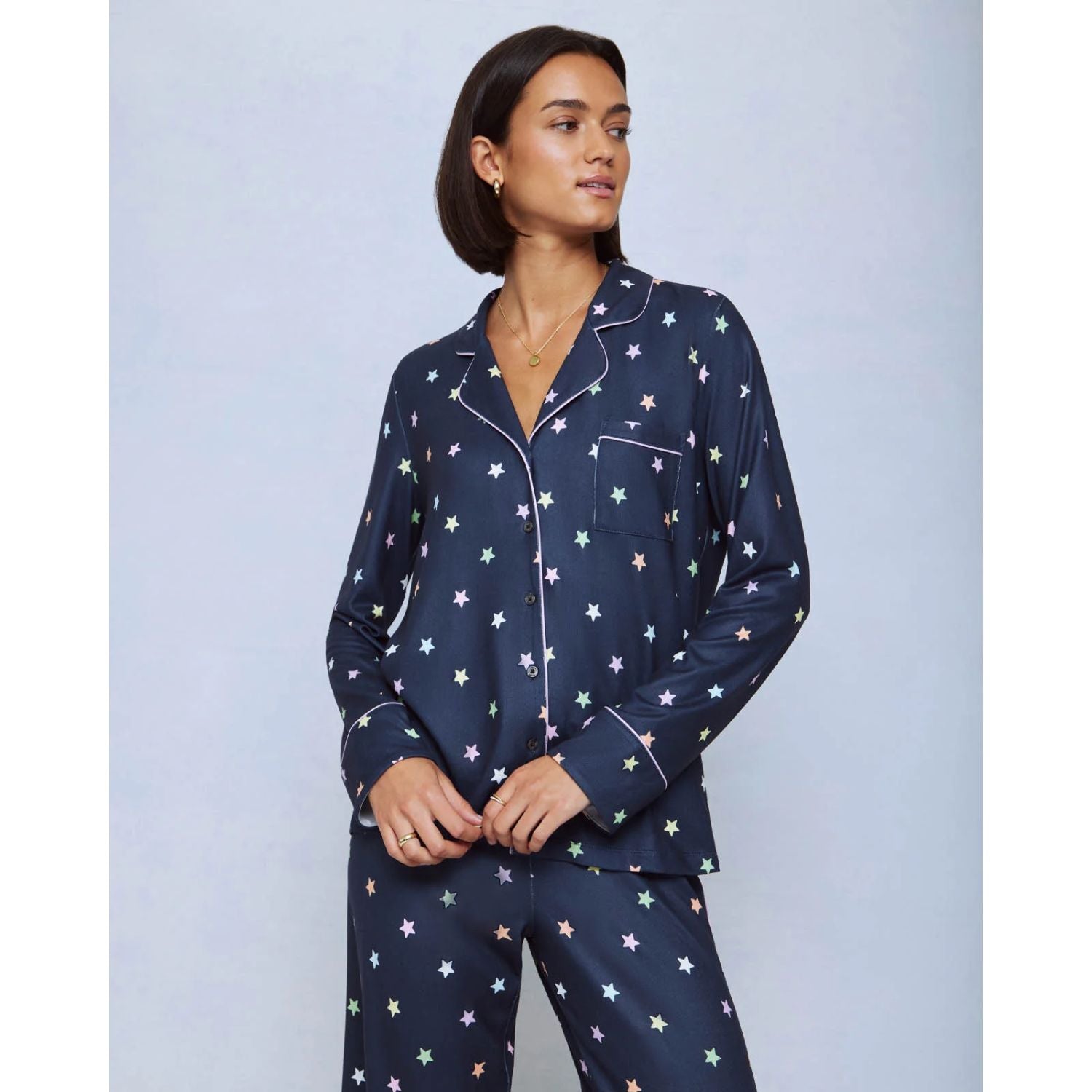 A cozy two-piece sleep set featuring brushed Pillowsoft fabric, a button-front top with contrast piping, and full-length drawstring pants for relaxing in comfort