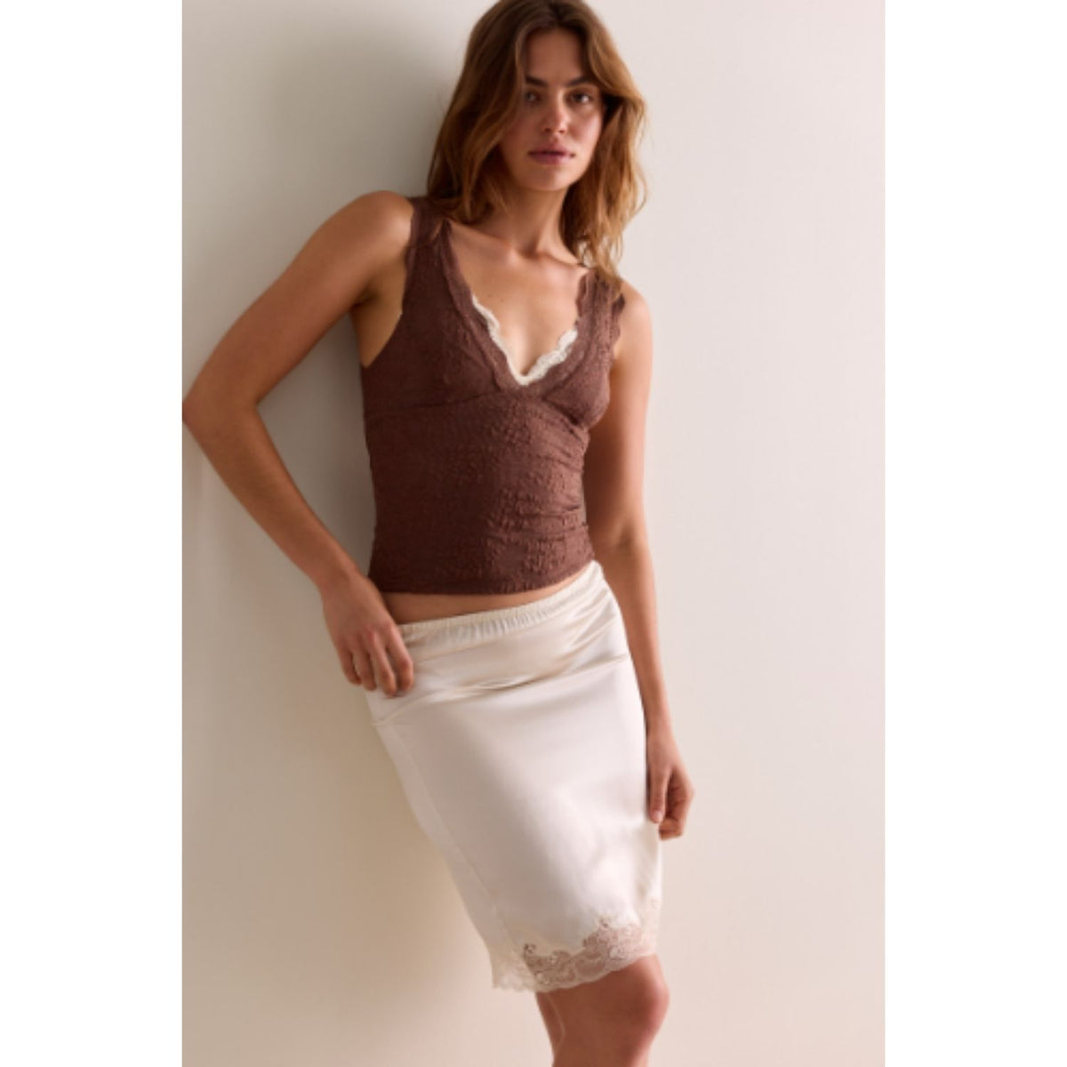 Women's lace tank top featuring a V-neckline, scalloped trim, and feminine open-back detailing