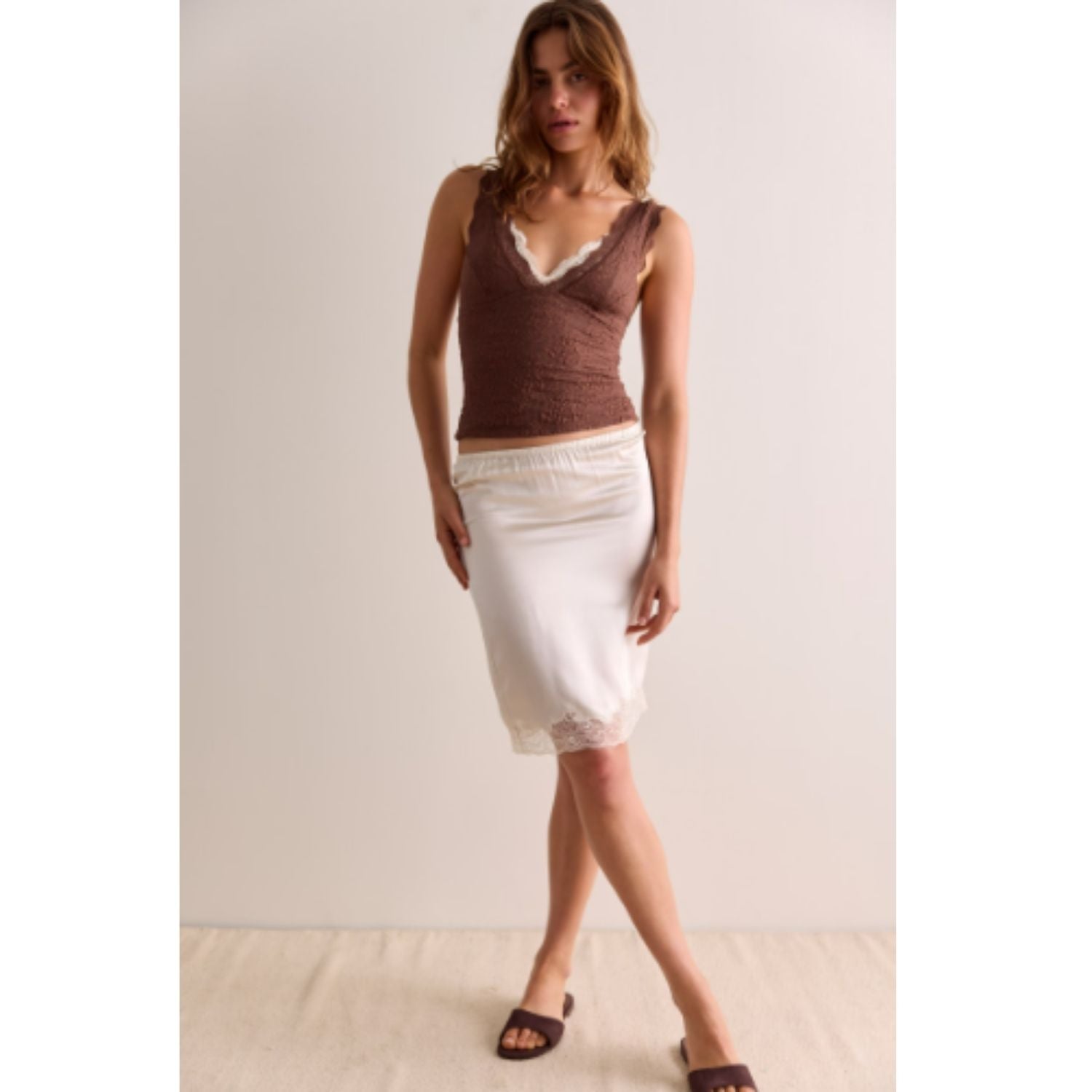 Women's lace tank top featuring a V-neckline, scalloped trim, and feminine open-back detailing