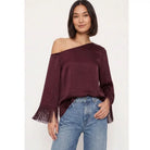 Off-shoulder satin blouse with an asymmetrical neckline and fringe-trimmed sleeves