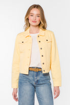 Cropped denim jacket with button front, chest pockets, and long sleeves styled over a tee and jeans