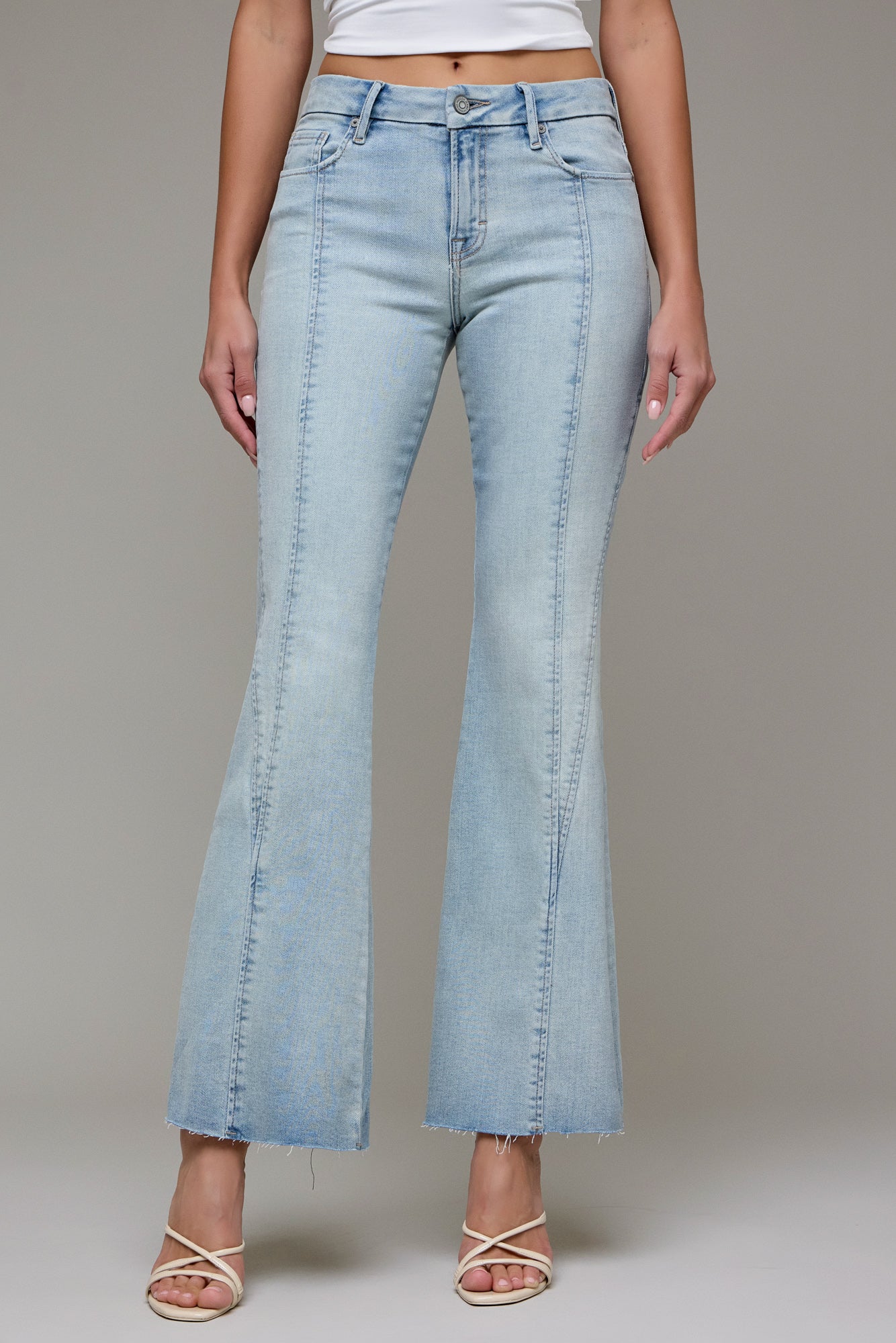 Light wash high-rise flare jeans featuring front seam detailing, a cropped raw hem, and a flattering fitted silhouette through the hips and thighs.