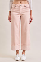 Cropped straight leg jeans with a mid-rise fit and wide cuffed hem worn with sneakers