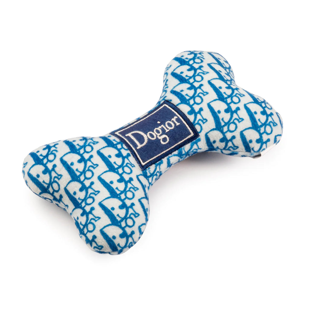 Dogior Bone Plush Dog Toy Blue Pattern.  This toy is the epitome of luxury for your stylish pup, featuring a built-in squeaker to provide endless entertainment. Designed to captivate dogs with a passion for luxury brands, this Dogior Bone combines fashion and fun.