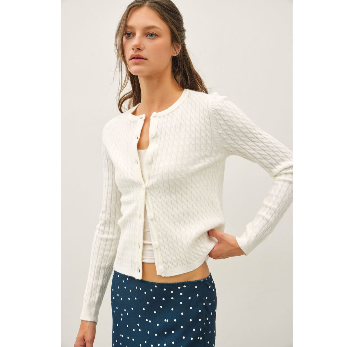 Women's fine cable knit cardigan with a crew neckline, button-up front, long sleeves, and slim-fit silhouette