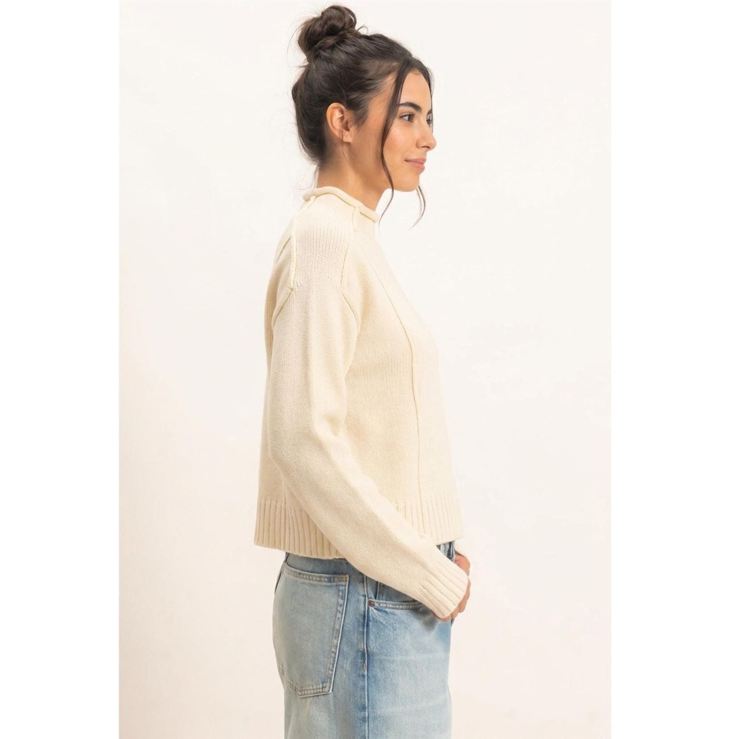 Moonbeam Mock Neck Sweater in cream with long sleeves, reversed seam detailing, and ribbed cuffs and hem.