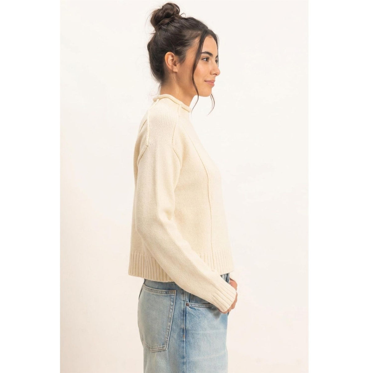 Moonbeam Mock Neck Sweater in cream with long sleeves, reversed seam detailing, and ribbed cuffs and hem.