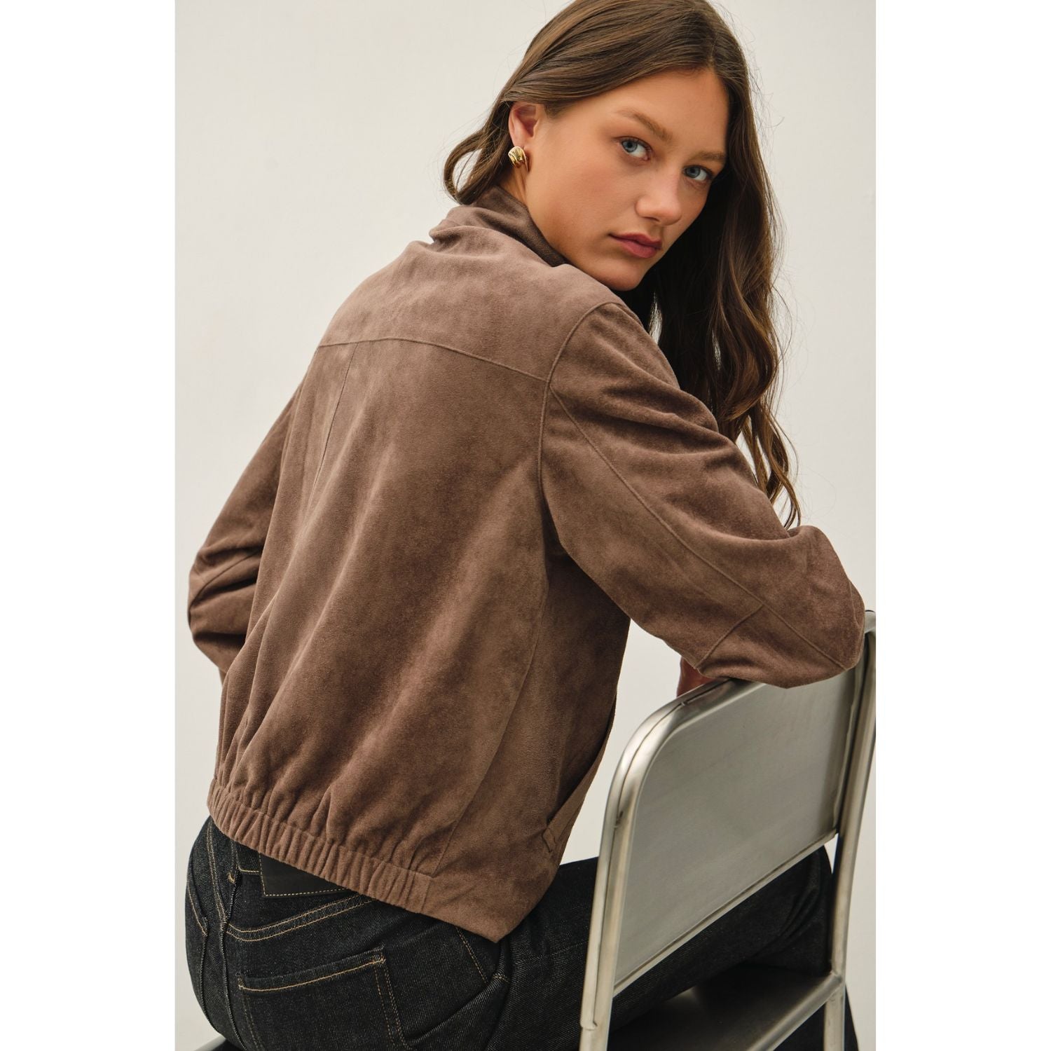 Women's suede-feel bomber jacket with a high collar, zipper and snap-button front, welt pockets, and banded hem