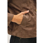 Women's suede-feel bomber jacket with a high collar, zipper and snap-button front, welt pockets, and banded hem