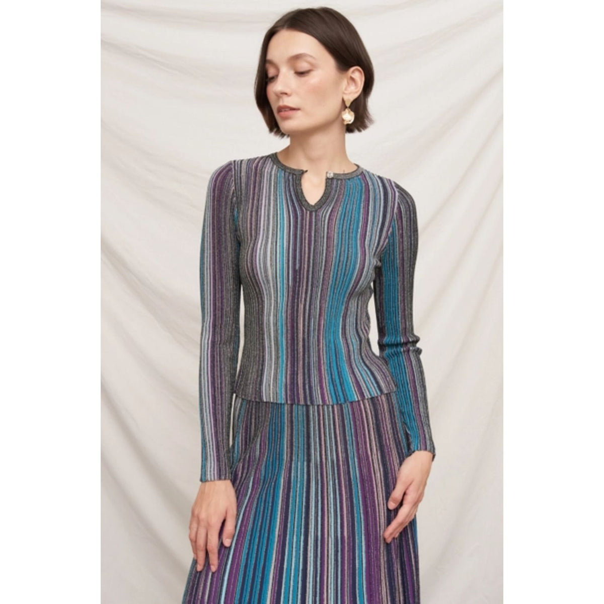 Fitted multicolor striped ribbed knit top with metallic shimmer, split neckline, and long sleeves.