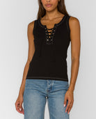 Black sleeveless lace-up tank top with contrast stitching and fitted silhouette paired with light wash jeans.