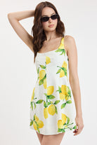 Printed mini dress with fitted silhouette and citrus pattern styled with sunglasses