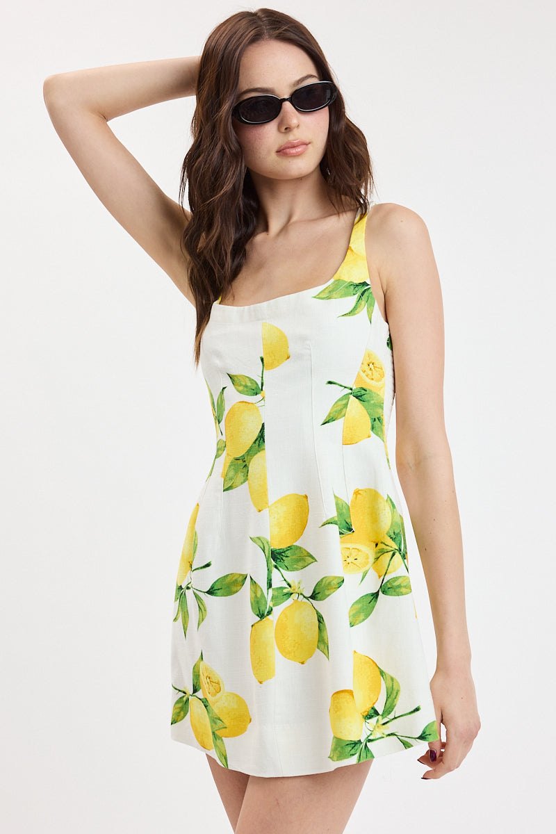 Printed mini dress with fitted silhouette and citrus pattern styled with sunglasses