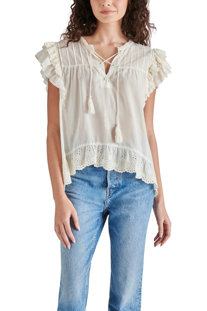 Steve Madden Bellamy Top Ivory. Set your boho spirit free in this breezy cotton top designed with eyelet-trimmed ruffles and a tassel-tie neck.