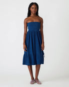 Strapless smocked midi dress with textured fabric and flowy skirt on model