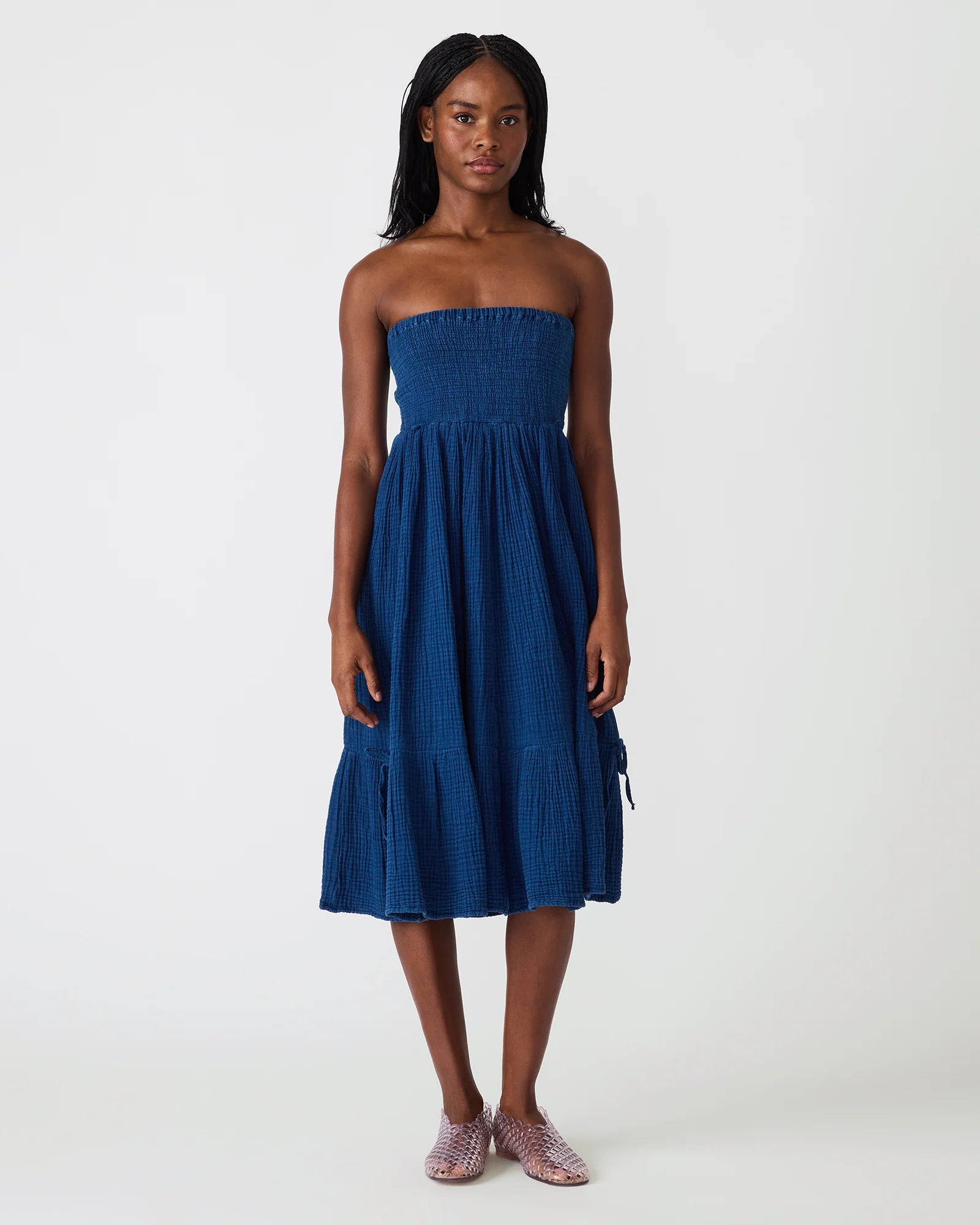Strapless smocked midi dress with textured fabric and flowy skirt on model
