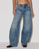 woman wearing a medium wash barrel jean