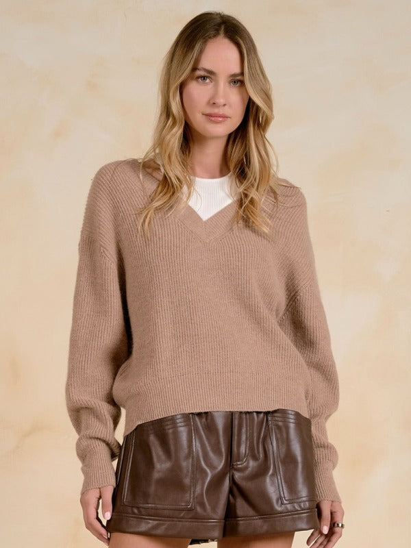 Woman wearing a ribbed knit V-neck sweater.