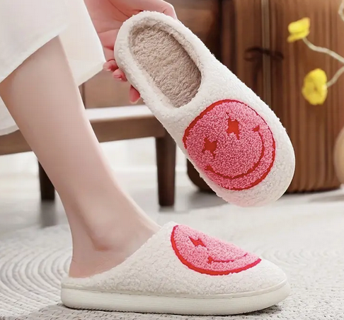Bolt Eyes Smiley Face Slippers Pink. Stay cozy, stylish, and happy with these Lightning bolt Eyes Smiley Face Slippers from Whim! Perfect for weekends with the fam or working from home.