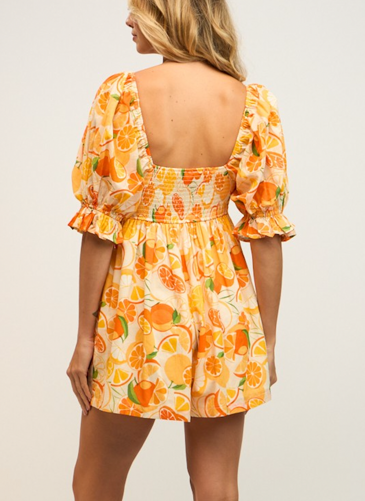 Katy Orange Puff Sleeve Romper Orange Print. This adorable puff sleeve romper features a square neck and orange print design for a cute and bight look that is sure to add some color to your day.