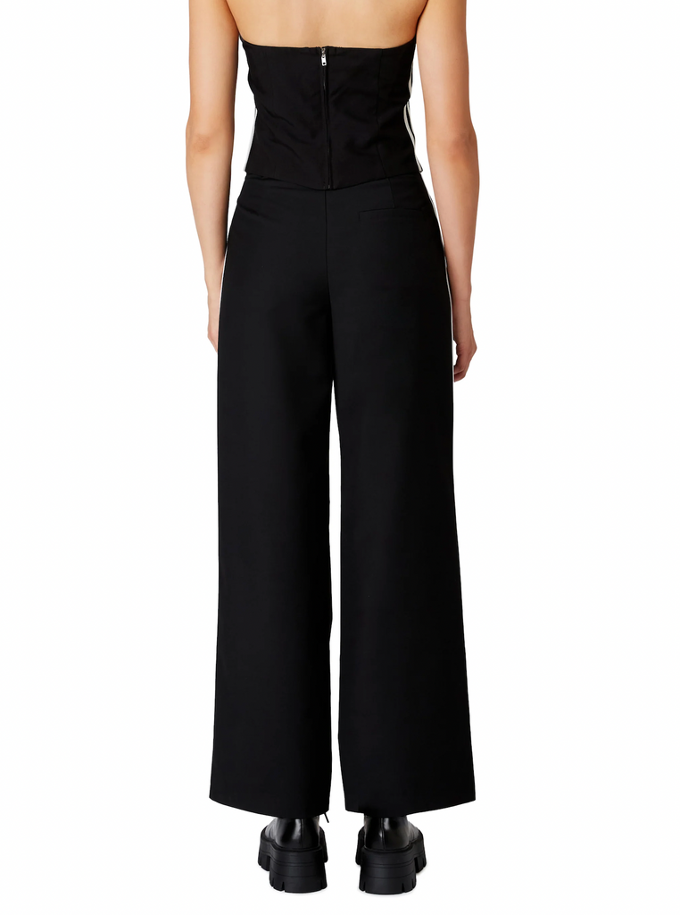 Nia Messi Trouser Black. This mid-rise pleated trouser features two contrast stripes at the side seam, wear them on their own or with the Kato Top for a cute sporty set.