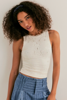 Sleeveless fitted top with eyelet detailing and high neckline styled with pinstripe pants