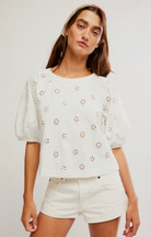 Short sleeve eyelet top with puff sleeves and relaxed fit styled with white denim shorts