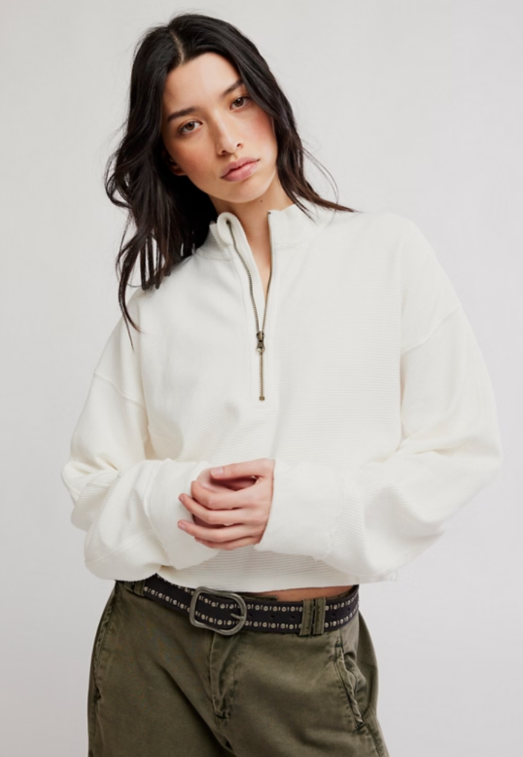 Model wearing a relaxed-fit ribbed half-zip pullover with a stand collar, long sleeves, and a quarter-zip neckline paired with olive green utility pants.