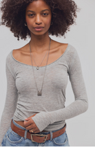 Women’s fitted long-sleeve top with a wide scoop neckline, side ruching, and thumbhole cuffs.