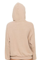 Beige hoodie worn by a person on a white background