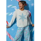 Ivory crewneck sweater with blue snowflake graphic, dropped shoulders, and contrasting blue cuffs