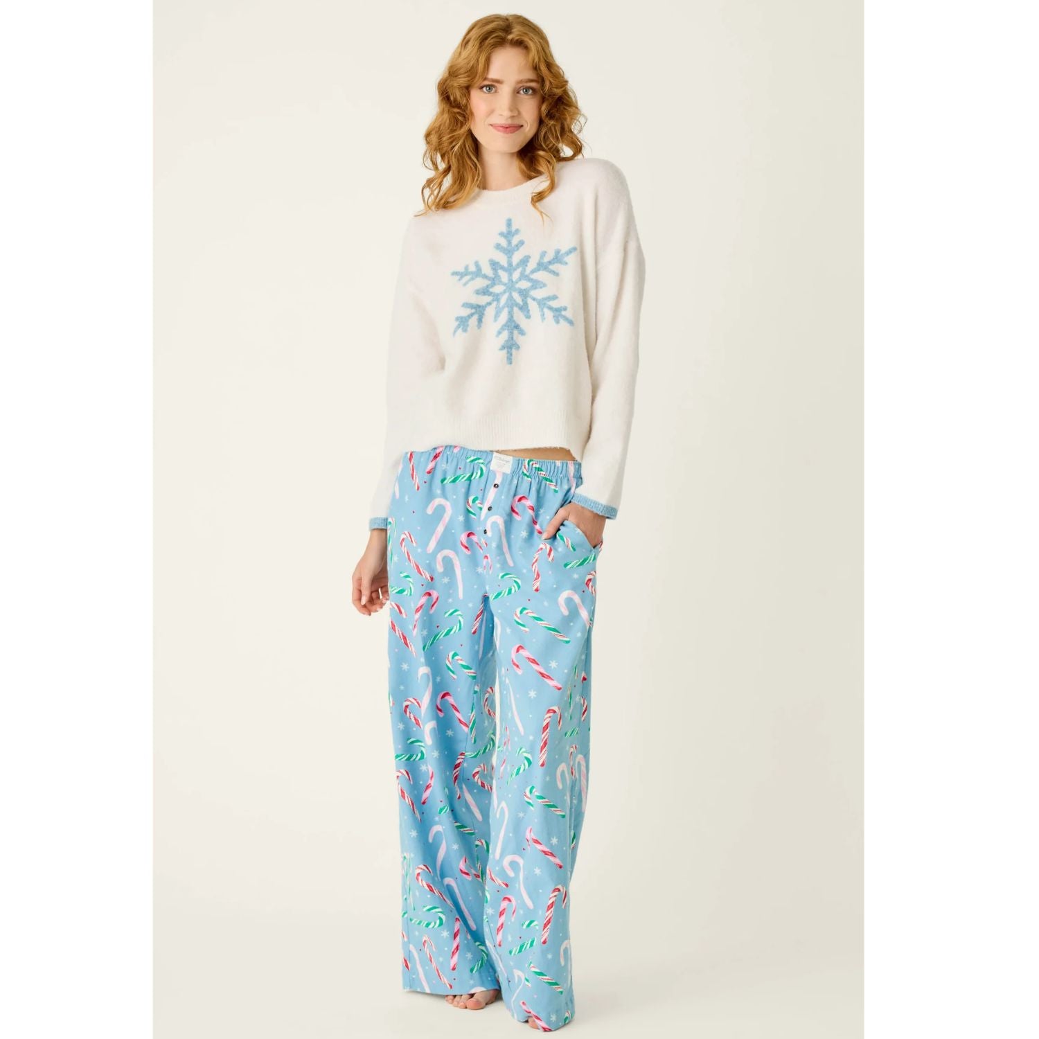 Ivory crewneck sweater with blue snowflake graphic, dropped shoulders, and contrasting blue cuffs