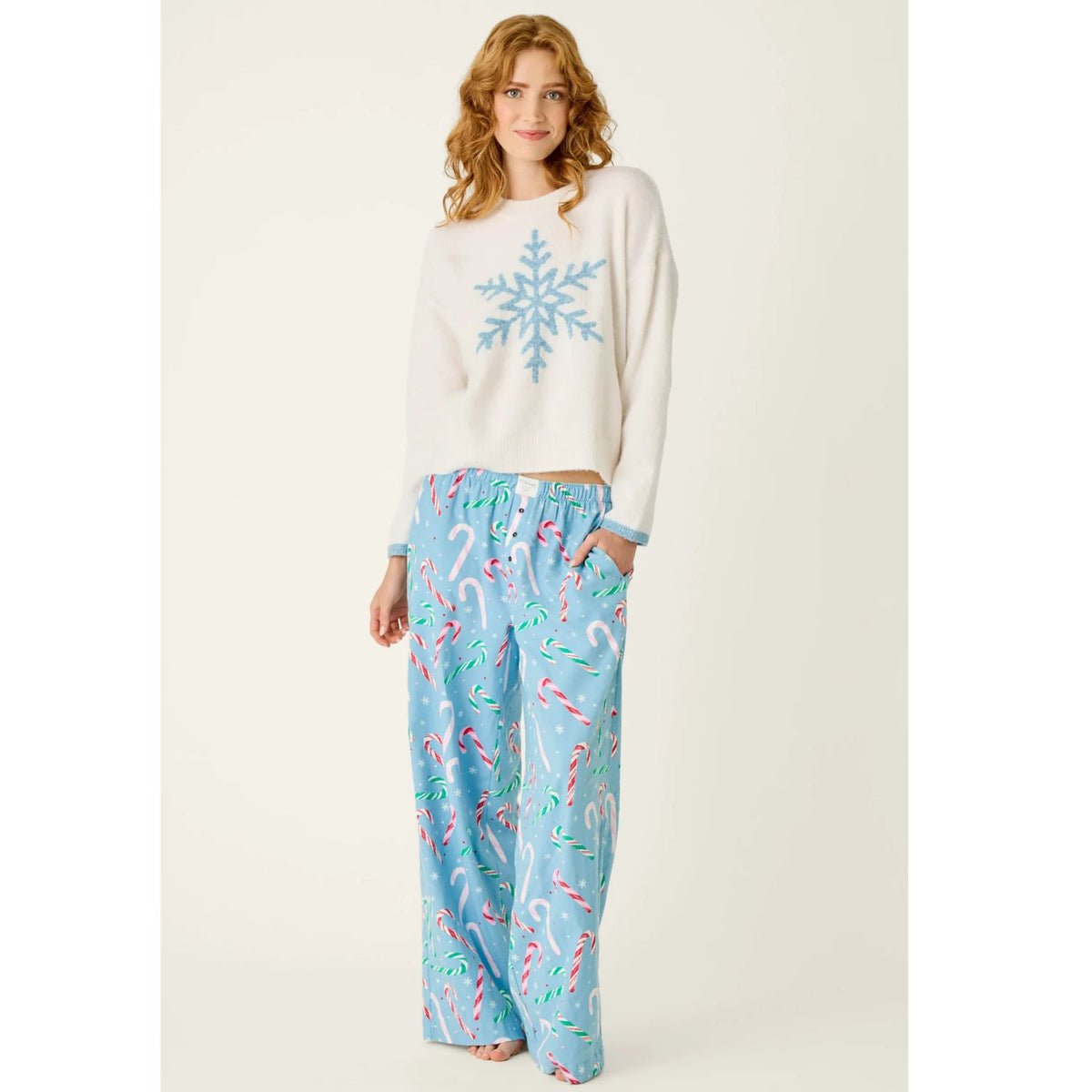 Ivory crewneck sweater with blue snowflake graphic, dropped shoulders, and contrasting blue cuffs