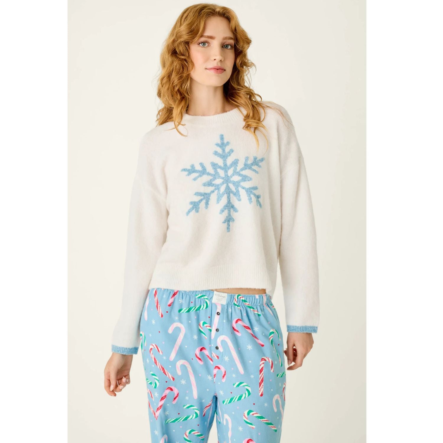 Ivory crewneck sweater with blue snowflake graphic, dropped shoulders, and contrasting blue cuffs
