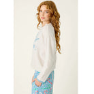 Ivory crewneck sweater with blue snowflake graphic, dropped shoulders, and contrasting blue cuffs