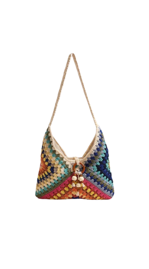 Colorful crocheted shoulder bag with patchwork knit design, wooden bead accents, and slouchy silhouette on a neutral background.